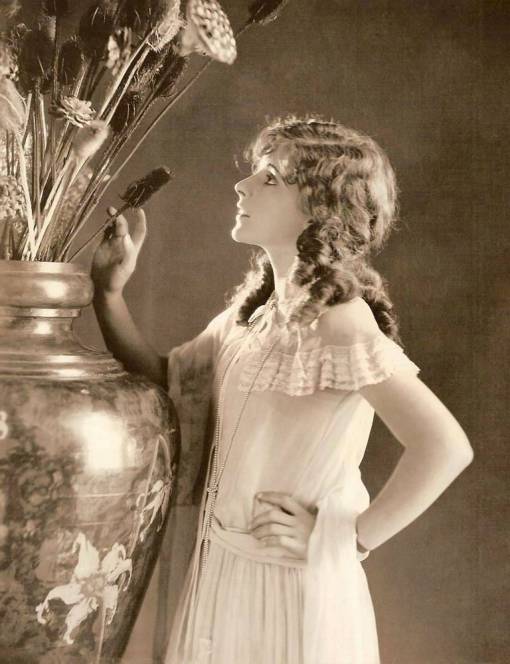 studio-portrait-movie-star-billie-dove-standing-profile-next-to-huge-vase-of-dried-flowers