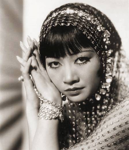 photo-movie-star-anna-may-wong-looking-into-camera-wearing-hands-to-side-of-face-wearing-jewelled-outfit