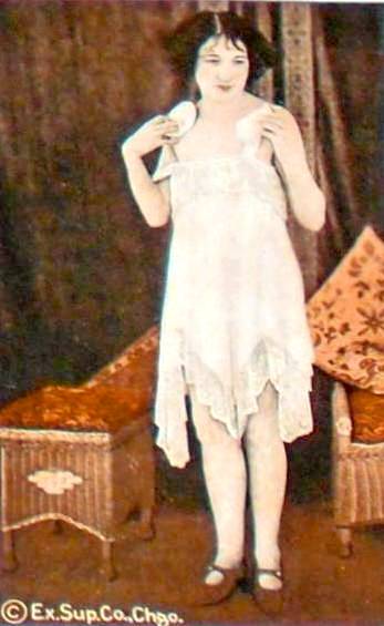 arcade-card-exhibit-supply-company-pin-up-woman-in-nightie-standing-and-powdering-herself-tinted-1920s1
