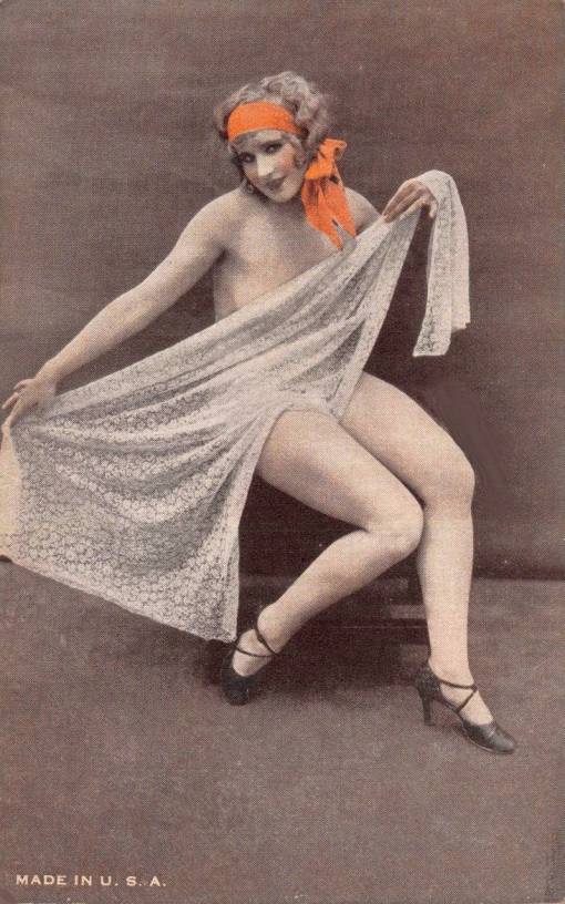 B ARCADE CARD - EXHIBIT SUPPLY COMPANY - PIN UP - NUDE WOMAN WITH A BIG RED BOW IN HER HAIR SITTING HOLDING SOME LACE IN FRONT OF HERSELF - TINTED - 1920s