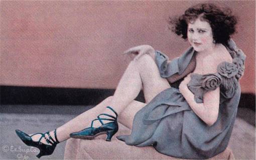ARCADE CARD - EXHIBIT SUPPLY COMPANY - PIN UP - WOMAN WEARING GREY NIGHTIE AND HIGH HEELS SITTING ON TABLE LOOKING DIRECTLY INTO CAMERA - TINTED - 1920s